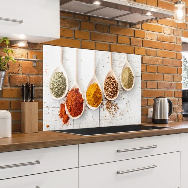 Glass splashback spices and herbs Wooden spoons with spices